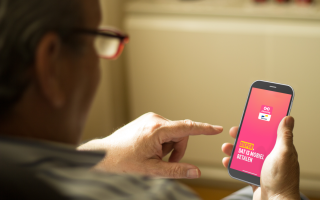 oudere man bekijkt payconiq app op zijn smartphone